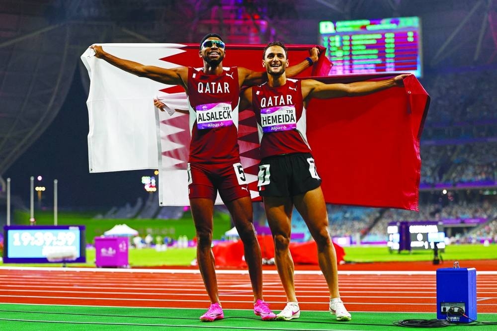 Qatar's Abderrahman Samba and Qatar's Bassem Hemeida celebrate after winning the Men's 400m Hurdles Final. REUTERS