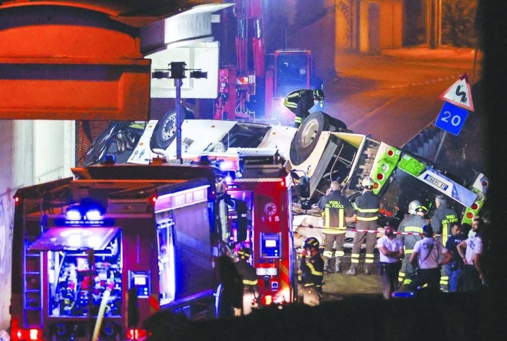 
Firefighters and rescue personnel work near a coach after it crashed off an overpass near Venice, in Mestre, Italy, yesterday. 