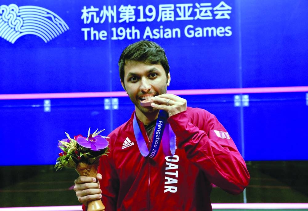 Qatar’s squash star Abdulla al-Tamimi poses with his bronze medal in Hangzhou, China. 