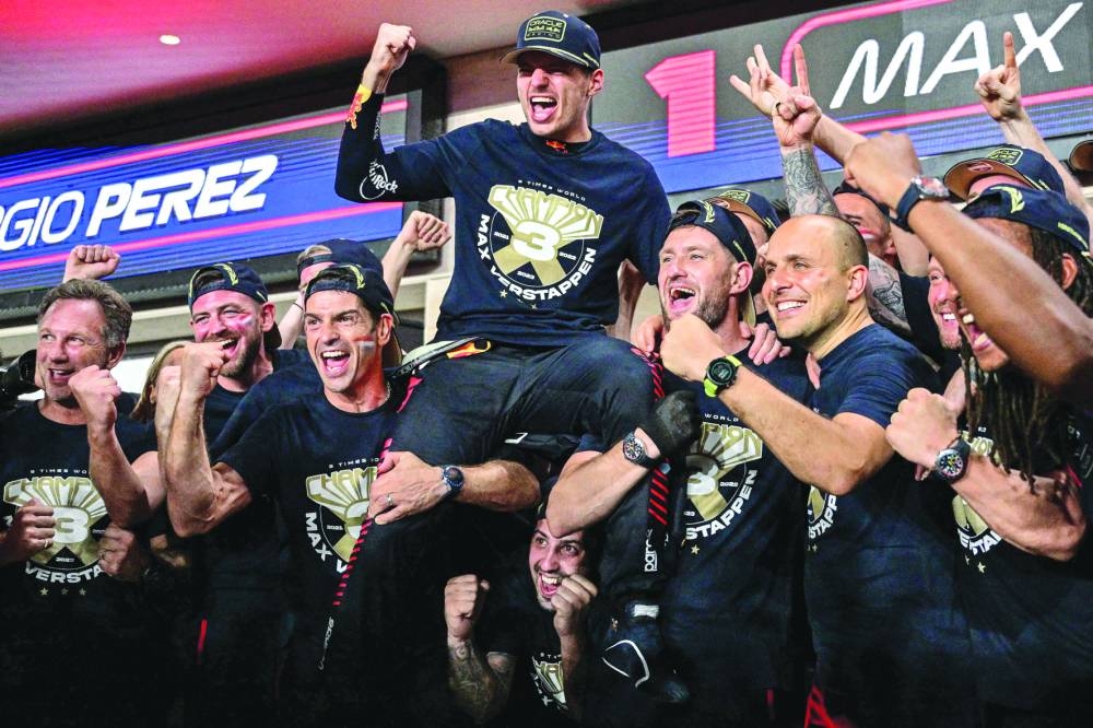 Red Bull Racing's Dutch driver Max Verstappen (C) celebrates his third world championship with his team after the sprint race ahead of the Qatari Formula One Grand Prix at the Lusail International Circuit Saturday.