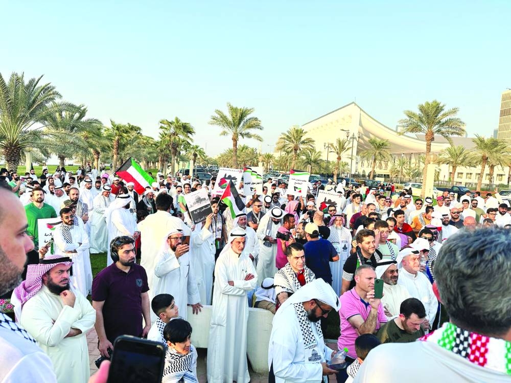 
Protesters in support of Palestinians and Hamas’ “Al Aqsa Flood operation” stand close to Kuwait’s parliament building holding banners and Palestinian flags in Kuwait City, yesterday. 