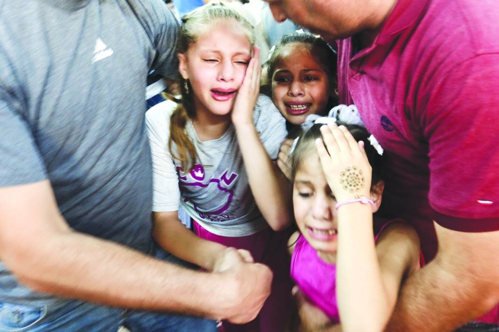 
Children react as they attend the funeral of Hamas fighters, who were killed by Israeli forces, in the northern Gaza Strip, yesterday. 