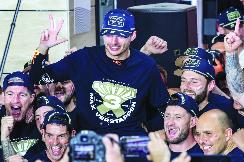 Red Bull Racing's Dutch driver Max Verstappen (C) celebrates his third world championship with his team after the sprint race ahead of the Qatari Formula One Grand Prix at the Lusail International Circuit on on Saturday. (AFP)