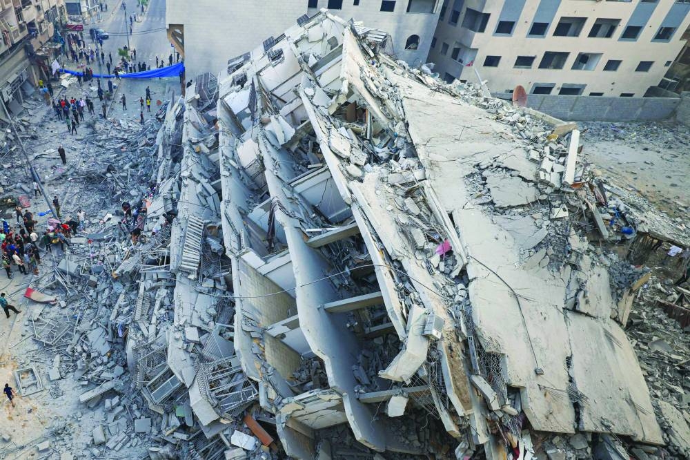 People inspect the ruins of a building destroyed in Israeli strikes in Gaza City, yesterday.