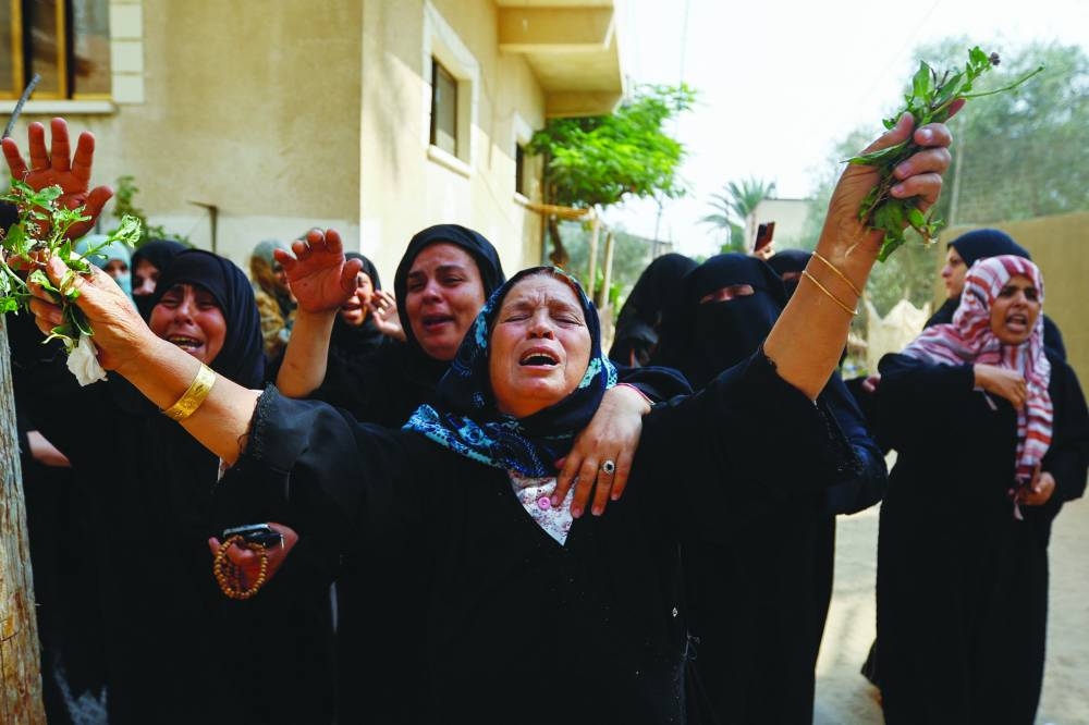 Mourners react during the funeral of Palestinian twin babies Ossayd and Mohamed Abu Hmaid, their mother and their three sisters, who health officials said were killed in Israeli strikes, during their funeral in Khan Younis in the southern Gaza Strip, yesterday.