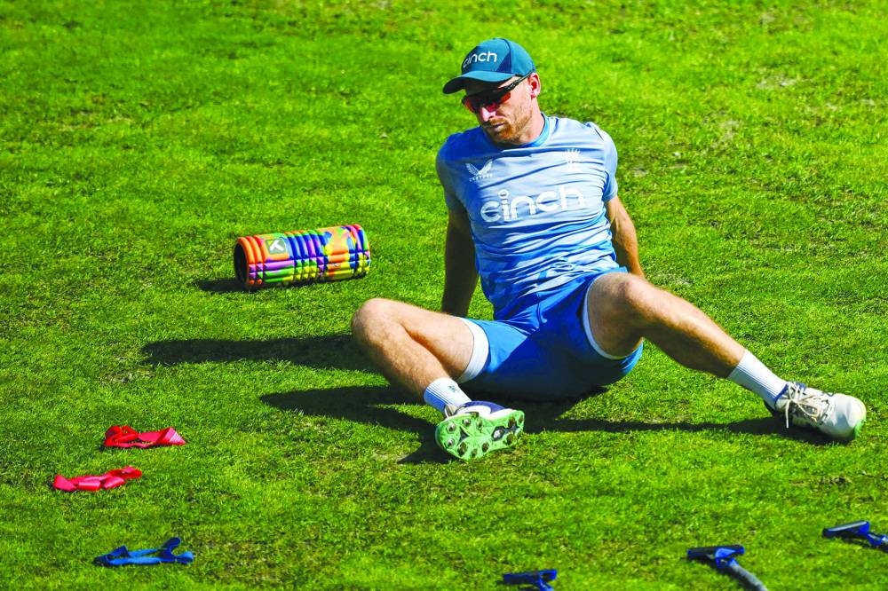 England’s Jos Buttler stretches during a practice session at the Himachal Pradesh Cricket Association Stadium in Dharamsala on Monday, ahead of the 2023 ICC World Cup match against Bangladesh. (AFP)