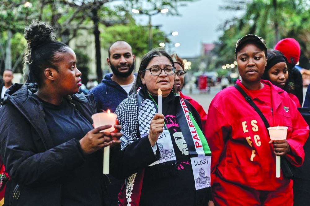 Supporters of the Kwazulu-Natal Palestine Solidarity Forum and other student and members of civil society groups hold a candle light vigil and a prayer for Gaza and Palestine in central Durban, South Africa, on Monday.
