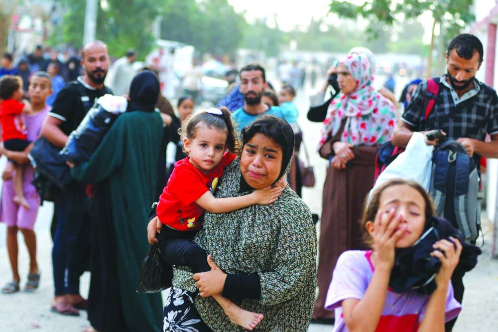 People flee their homes in Khan Yunis, amid Israeli strikes in the southern Gaza Strip, on Monday.