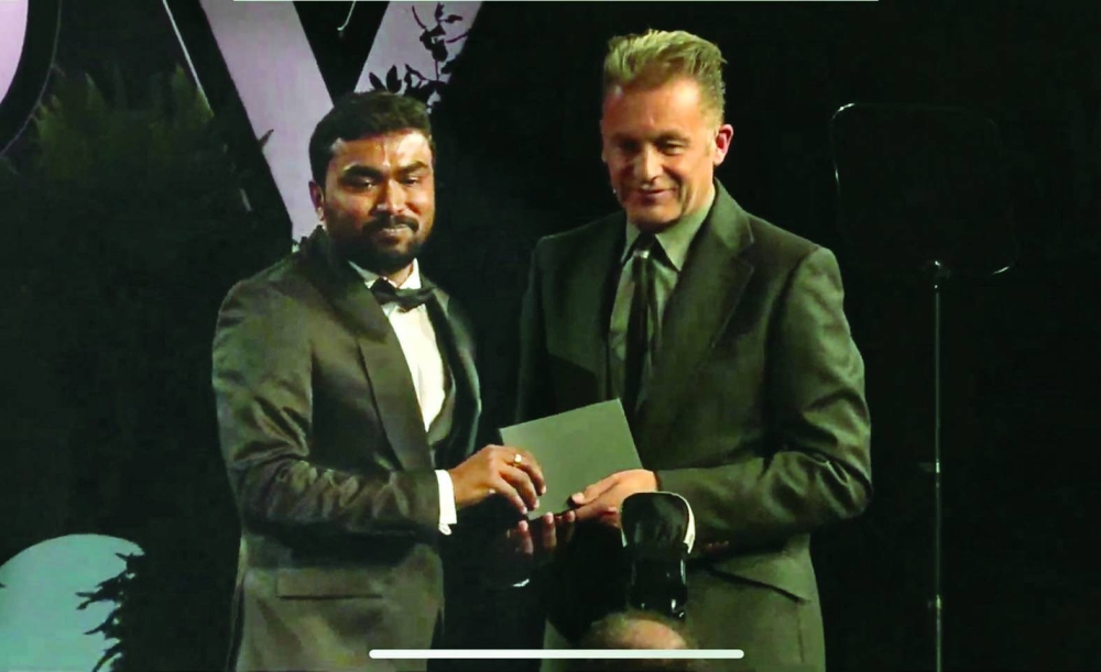 Vishnu Gopal (left) receiving the award in London.