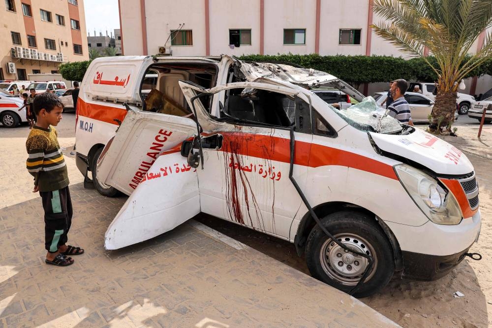 Children view a destroyed ambulance parked along a street in Khan Yunis in the southern Gaza Strip, Wednesday.