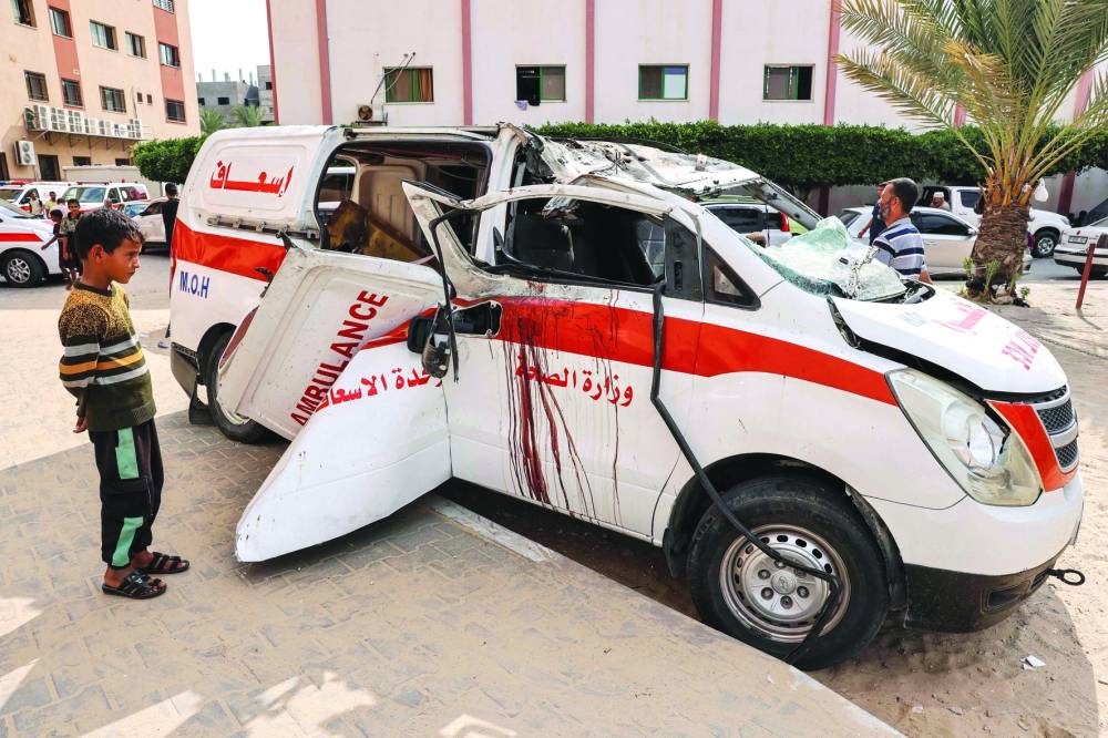 
Children view a destroyed ambulance parked along a street in Khan Yunis in the southern Gaza Strip, yesterday. 