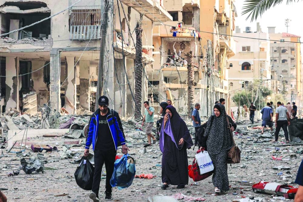 
Palestinians leave Al-Karama neighbourhood in Gaza City to safer areas, yesterday. 