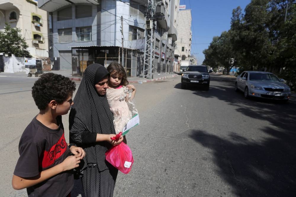 Palestinians flee their houses heading toward the southern part of Gaza Strip after Israel's call for more than 1 million civilians in northern Gaza to move south within 24 hours, amid the Israeli-Palestinian conflict in Gaza City Friday. REUTERS