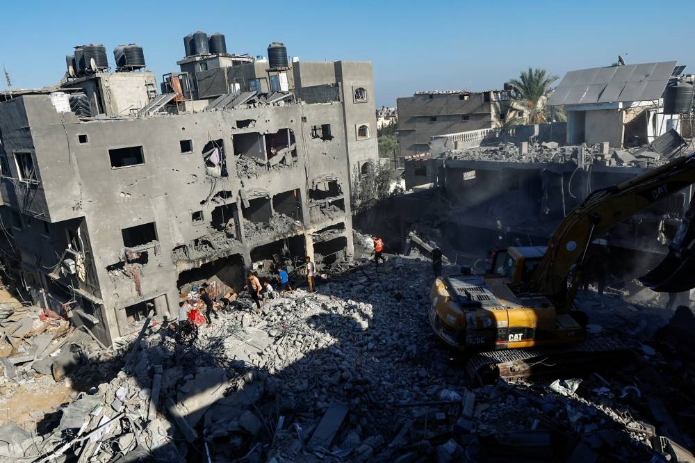 Palestinians search for casualties under the rubble in the aftermath of Israeli strikes amid the ongoing conflict between Israel and the Palestinian Islamist group Hamas, in Khan Younis in the southern Gaza Strip Friday. REUTERS/Ibraheem Abu Mustafa
