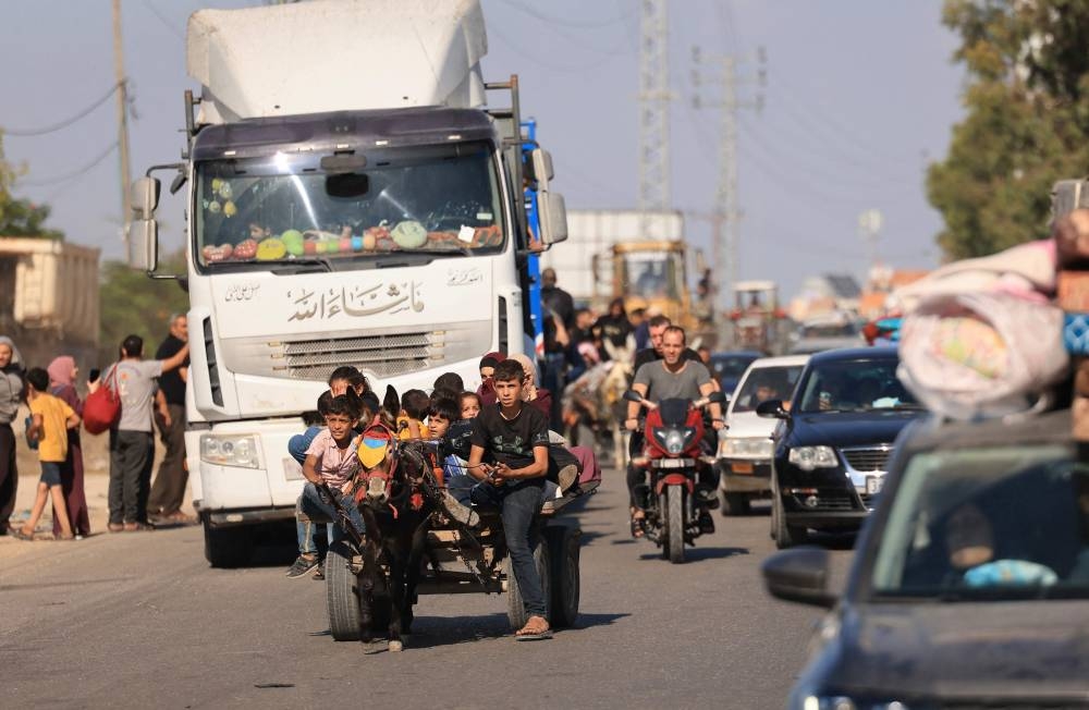 Riding a donkey drawn cart as family along with hundreds of other Palestinian carrying their belongings flee following the Israeli army's warning to leave their homes and move south before an expected ground offensive, in Gaza City on Friday. AFP