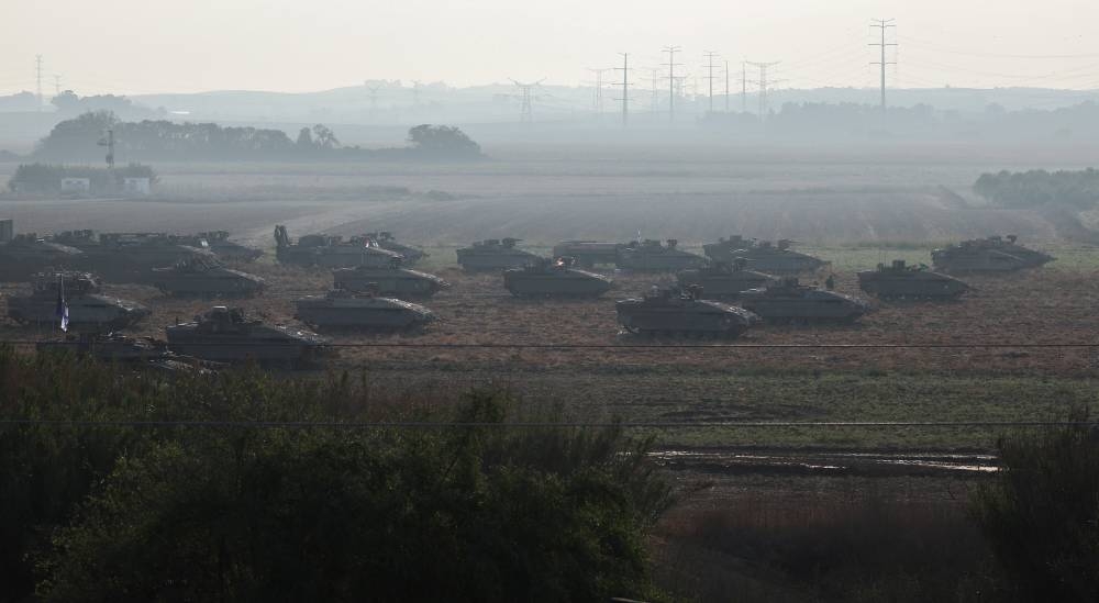 Israeli tanks and military vehicles take position near Israel's border with the Gaza Strip, in southern Israel, Saturday. REUTERS