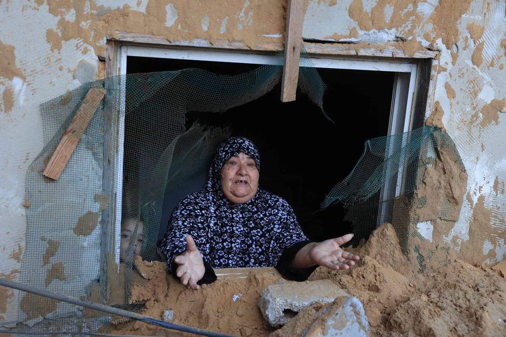 A Palestinian woman reacts to the damage after an Israeli military strike on the Rafah refugee camp, in the southern of Gaza Strip Sunday. AFP