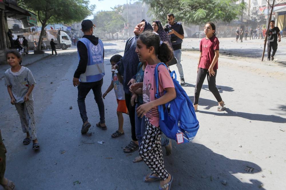 Palestinians react following Israeli strikes in Gaza City October 15, 2023. REUTERS