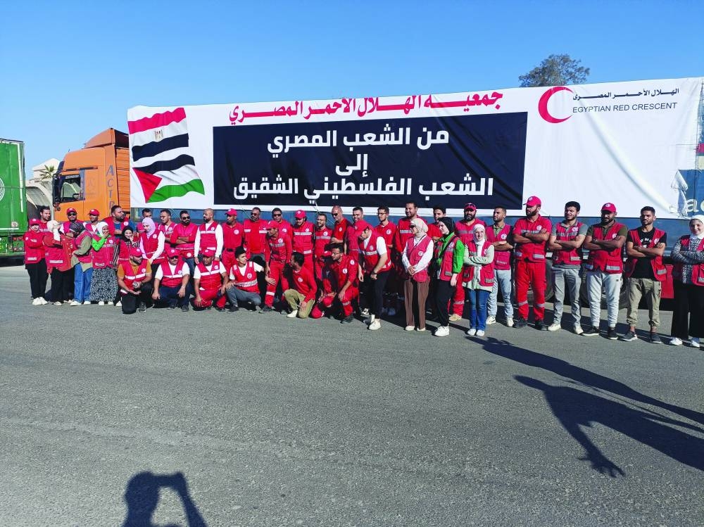 Members of the Egyptian Red Crescent pose for a picture in front of a truck carrying humanitarian aid to Palestinians by Egyptian NGOs, as they wait for an agreement on the Rafah border crossing to enter Gaza, amid the ongoing conflict, in the city of Al-Arish in Egypt’s Sinai peninsula, Sunday.