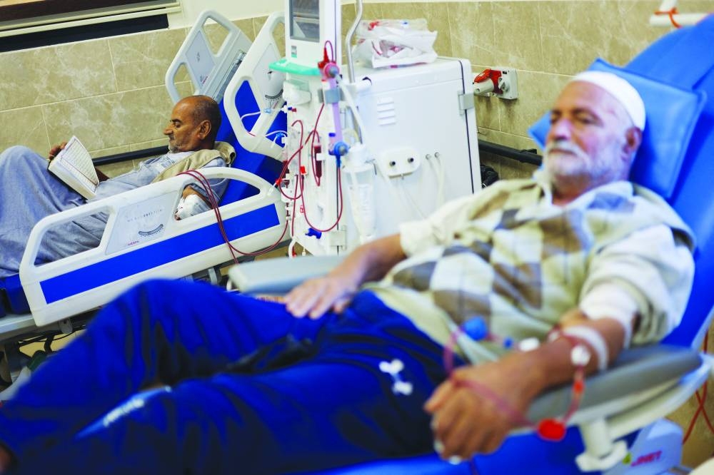 A Palestinian kidney patient reads while lying on a hospital bed, as health officials say they are running out of fuel to operate dialysis devices, amid the ongoing conflict, at Naser hospital in Khan Yunis in the southern Gaza Strip, Sunday.