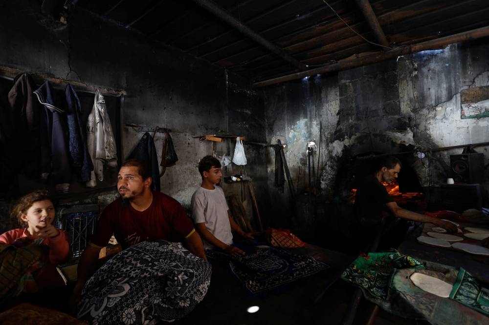 Palestinians bake bread on firewoods, amid fuel and power shortages, as the conflict between Hamas and Israel continues, in Khan  Younis in the southern Gaza Strip, Monday. REUTERS