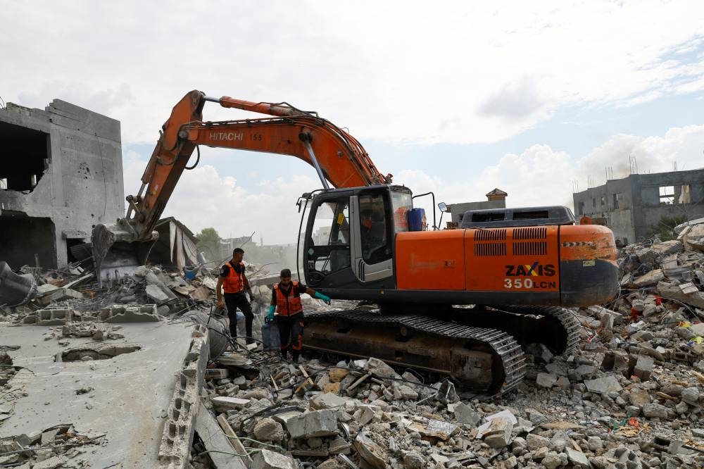 Rescue workers search for casualties at a site of a house destroyed by Israeli strikes in Khan Younis in the southern Gaza Strip Monday. REUTERS