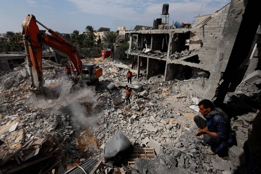 Palestinians search for casualties under the rubble at a site of a house destroyed by Israeli strikes in Khan Younis in the southern Gaza Strip Monday. REUTERS