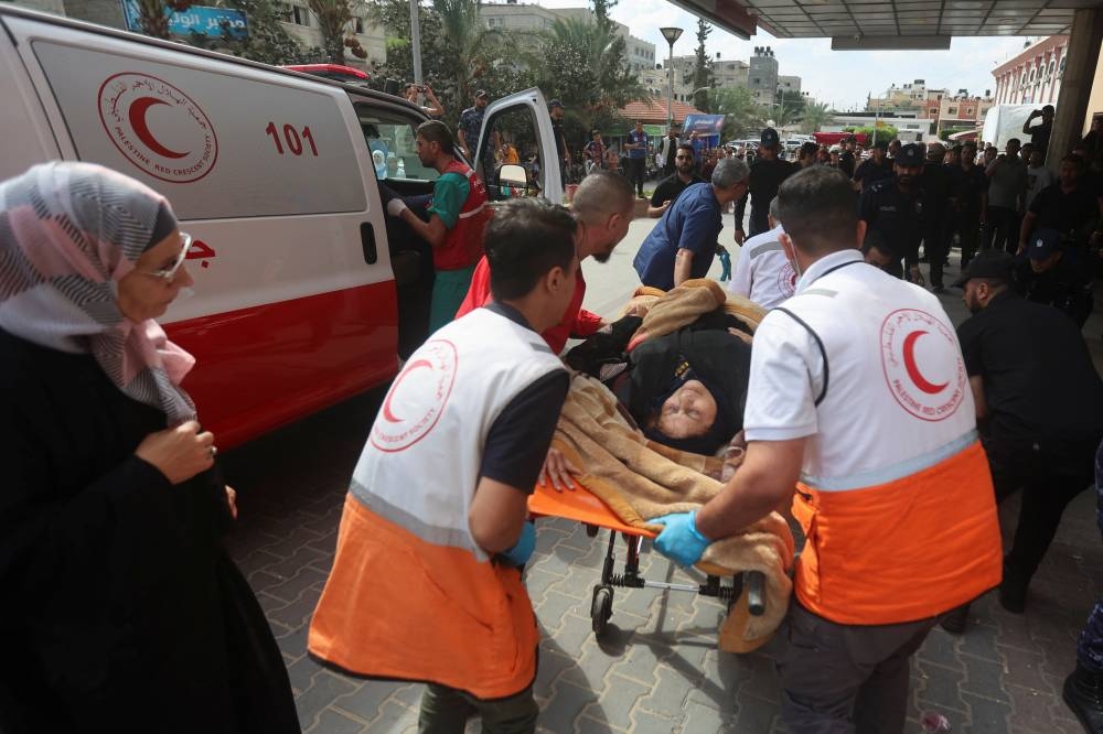 A woman, wounded in Israeli strikes, is brought to a hospital in Khan Younis in the southern Gaza strip,  Monday. REUTERS/Ahmed Zakot