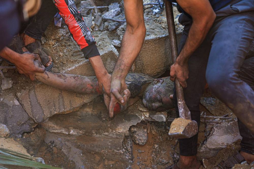 A Palestinian youth is pulled out from under the rubble of a building following an Israeli airstrike in Rafah, in the southern of Gaza Strip, on Monday. AFP