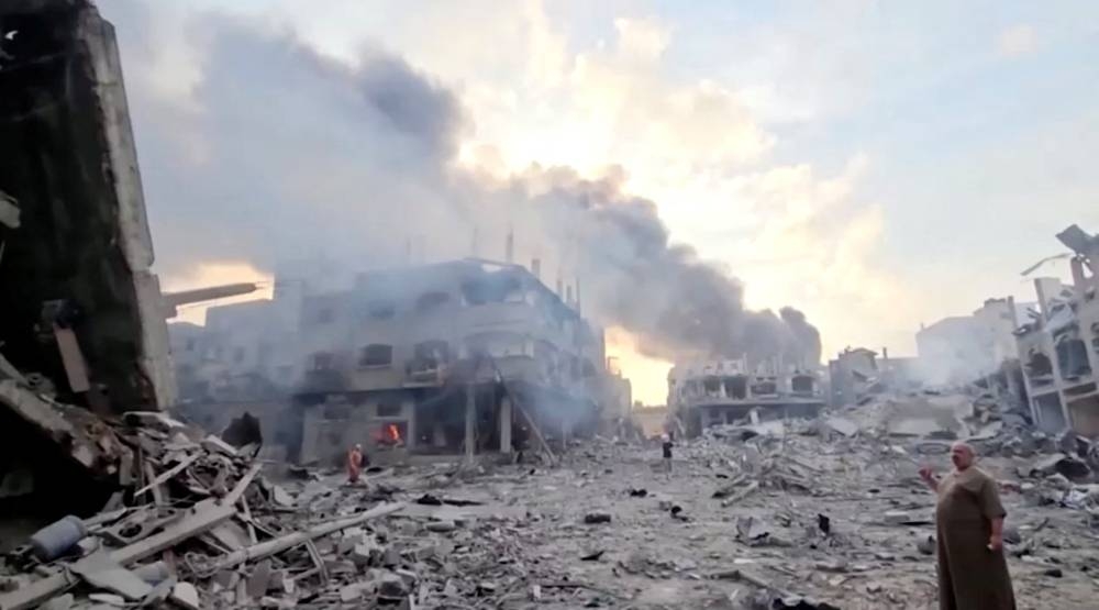People survey the destruction at Gaza's Jabalia refugee camp, following Israeli strikes on the enclave, in this still image from video obtained by REUTERS.