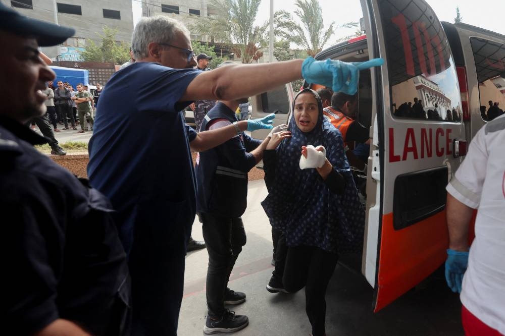 A woman, wounded in Israeli strikes, arrives at a hospital in Khan Younis in the southern Gaza strip, Monday. REUTERS