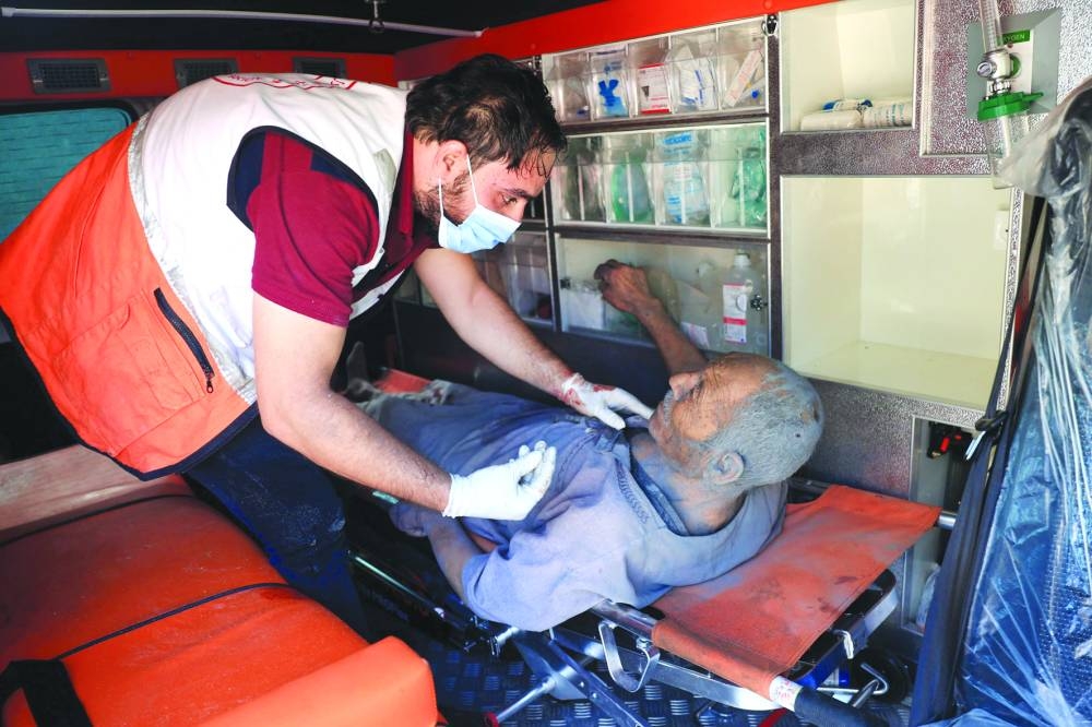 
A rescuer checks an elderly man covered in dust and dirt from collapsed buildings following an Israeli airstrike in Rafah, yesterday. 