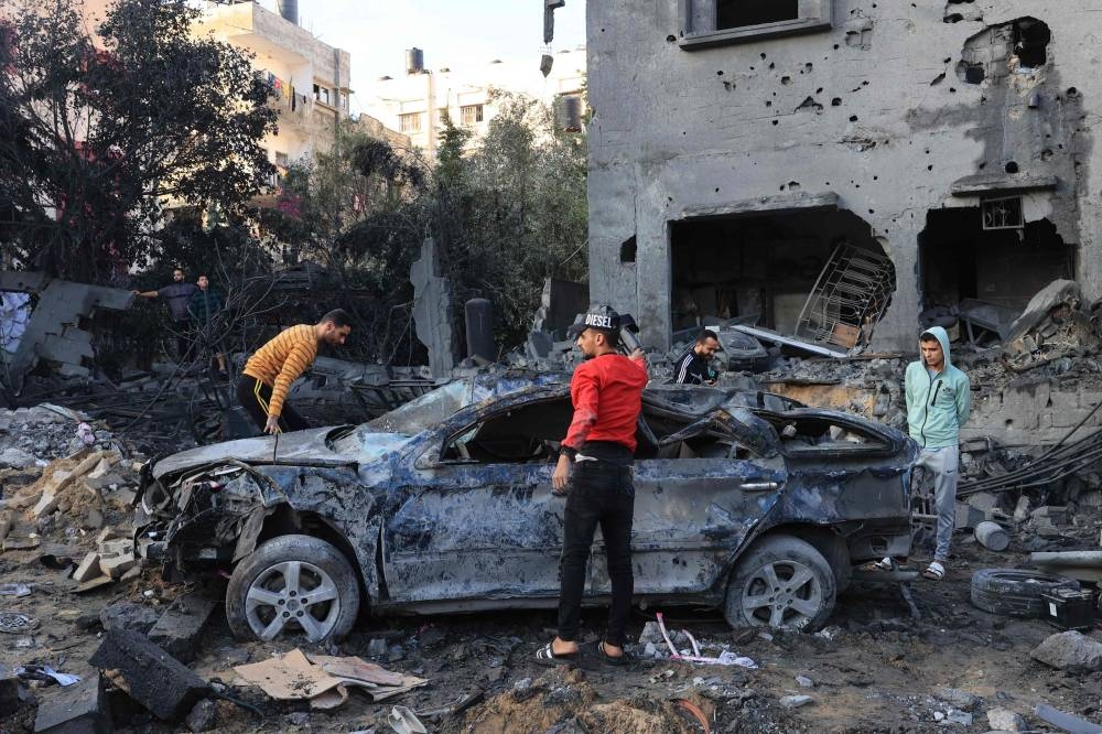 Palestinians inspect the rubble of a building after an Israeli airstrike on the Rafah refugee camp, in the southern Gaza Strip Tuesday. AFP