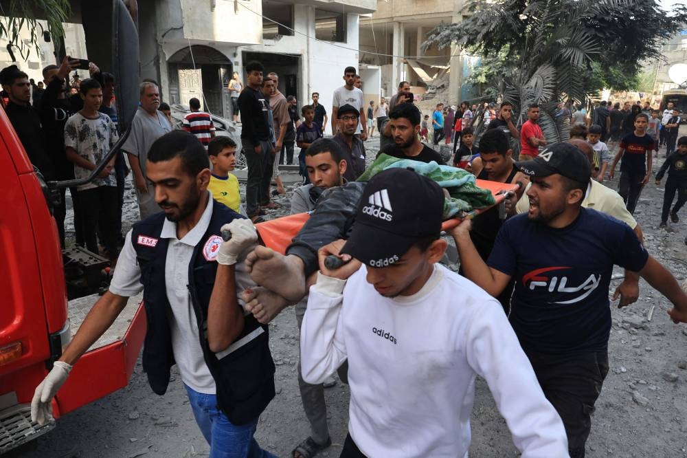 Palestinians evacuate a body following an Israeli airstrike on the Rafah refugee camp, in the southern Gaza Strip Tuesday. AFP