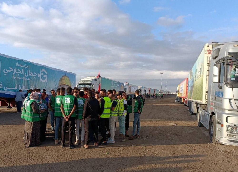 Egyptian volunteers wait next to a truck convoy carrying humanitarian aid from Egyptian NGOs for Palestinians at the Rafah crossing, for a decision for it to open, to enter Gaza, amid the ongoing conflict between Israel and the Palestinian Islamist group Hamas, in Rafah, Egypt Tuesday. REUTERS