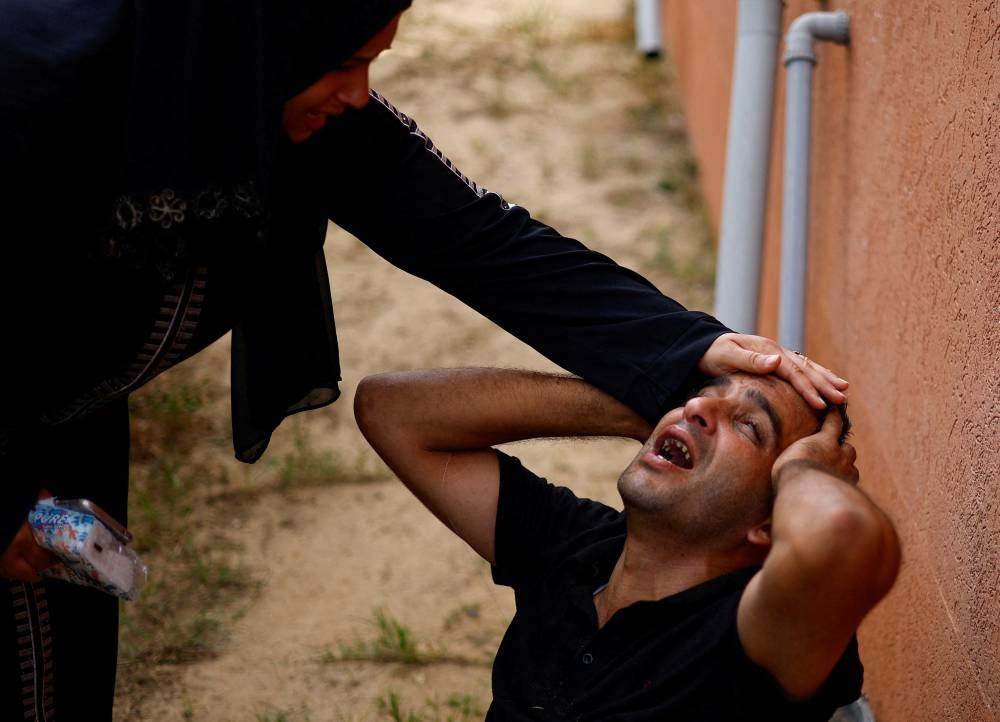 Mourners react next to the bodies of Palestinians killed in Israeli strikes, at a hospital in Khan Younis in the southern Gaza Strip Tuesday. REUTERS