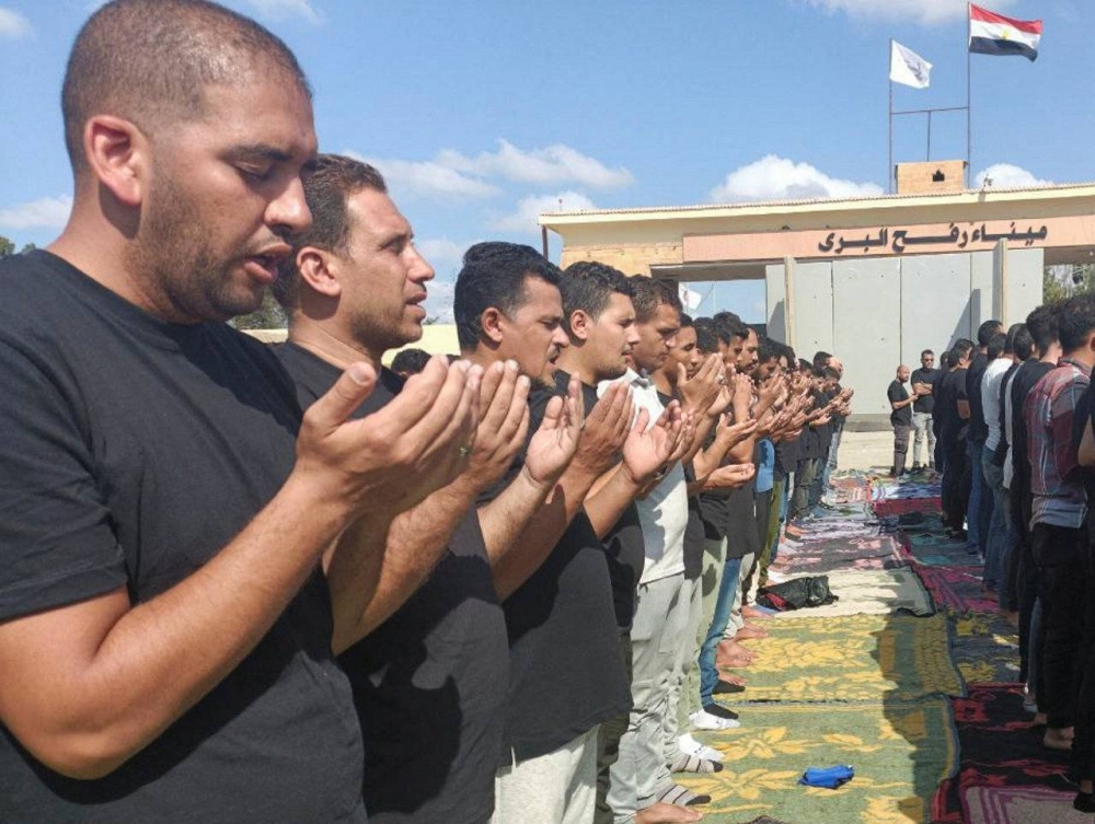 Egyptian volunteers gather for a funeral prayer, for those killed in a blast at a hospital in Gaza on October 17, in front of the Rafah crossing, as trucks carrying humanitarian aid for Palestinians await a decision for it to open to enter Gaza, amid the ongoing conflict between Israel and the Palestinian Islamist group Hamas, in Rafah, Egypt Wednesday. REUTERS