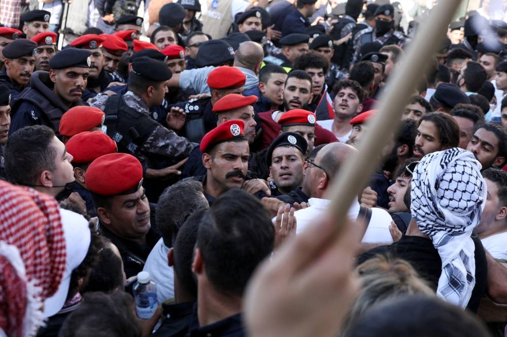 Members of the security forces confront the demonstrators during a pro-Palestinian protest, after hundreds of Palestinians were killed in a blast at Al-Ahli hospital in Gaza that Israeli and Palestinian officials blamed on each other, in Amman, Jordan, Wednesday. REUTERS
