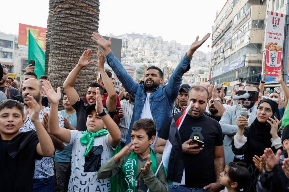 Palestinians take part in a protest in support of the people in Gaza, after hundreds of Palestinians were killed in a blast at Al-Ahli hospital in Gaza that Israeli and Palestinian officials blamed on each other, in Nablus in the Israeli-occupied West Bank Wednesday. REUTERS