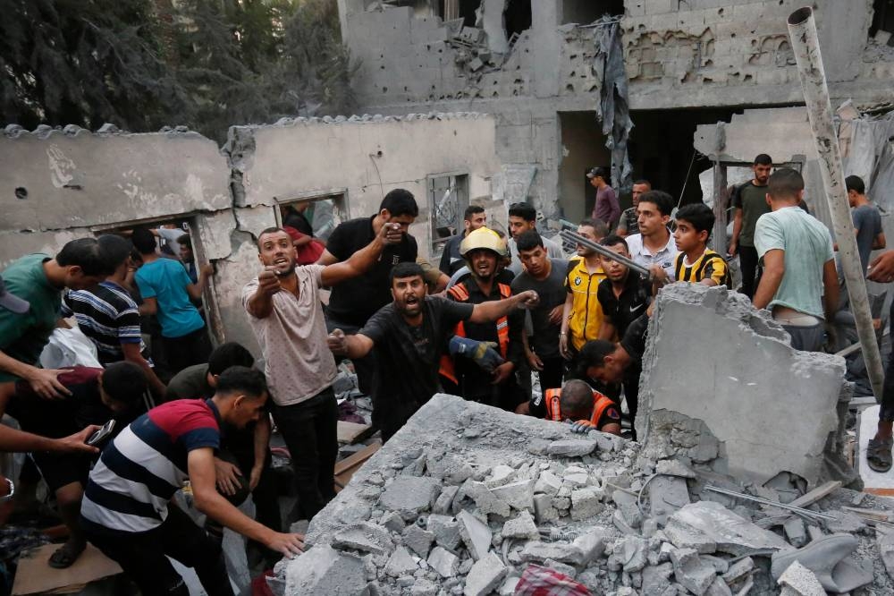 People search for victims and survivors following an Israeli strike on the town of Deir Al-Balah in the central Gaza Strip Wednesday. AFP