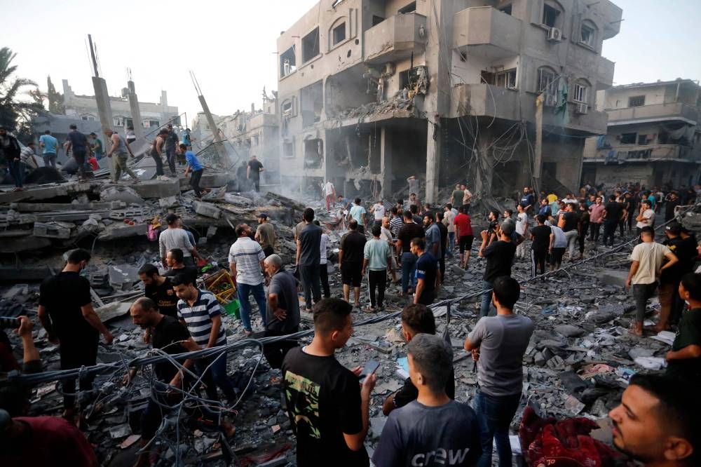 People search for victims and survivors following an Israeli strike on the town of Deir Al-Balah in the central Gaza Strip on Wednesday. AFP