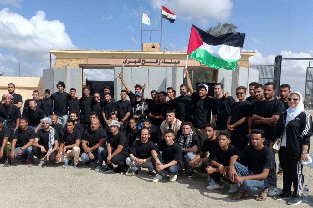 Egyptian volunteers gather in front of the Rafah crossing, after a blast at a hospital in Gaza on Tuesday, as trucks carrying humanitarian aid for Palestinians await a decision for it to open to enter Gaza. REUTERS