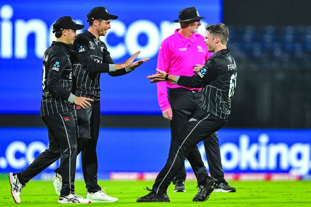 New Zealand’s Lockie Ferguson (right) celebrates with teammates after taking the wicket of Afghanistan’s captain Hashmatullah Shahidi at the MA Chidambaram Stadium. (AFP)