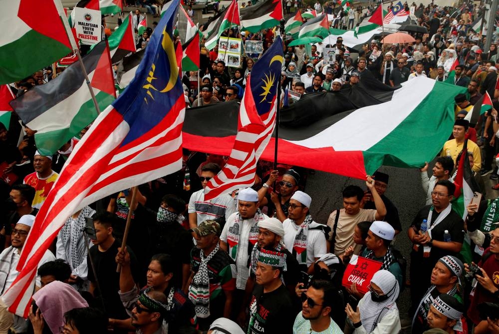 Malaysians hold their country's and Palestinian flags as they protest outside the US embassy in support of Palestinians in Gaza after an explosion at a hospital in Gaza, as the conflict between Israel and Hamas continues, in Kuala Lumpur, Malaysia, Friday. REUTERS