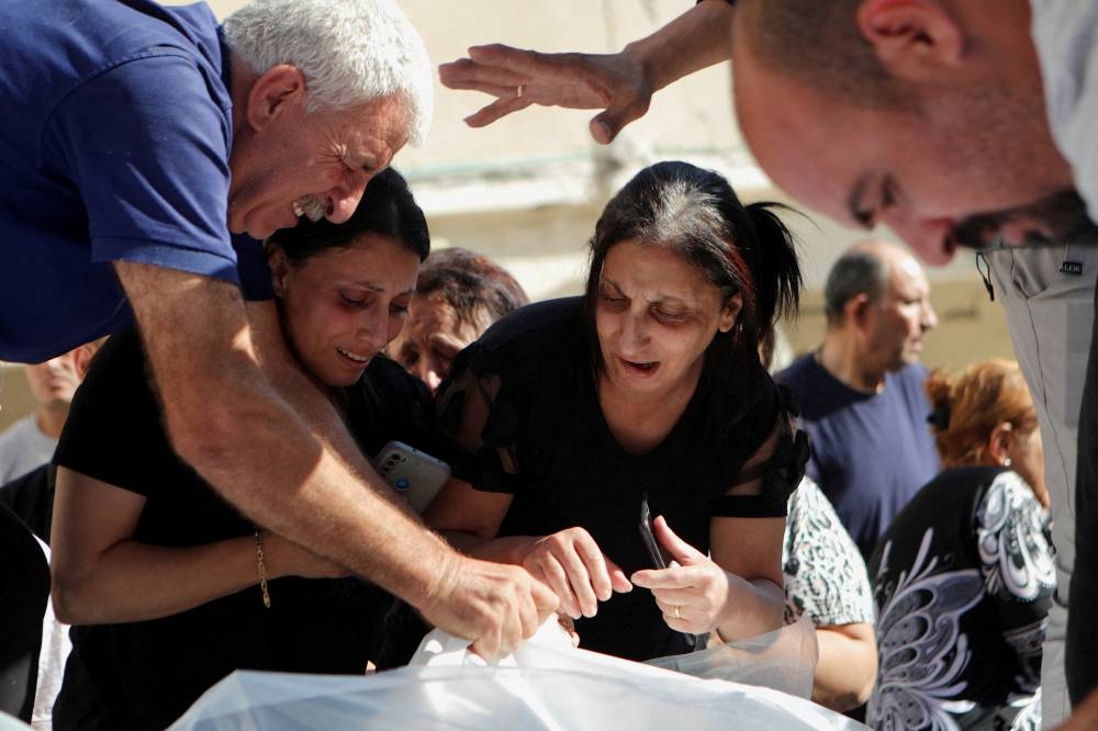 Mourners attend a funeral for Palestinians killed in an Israeli strike that damaged the Greek Orthodox Saint Porphyrius Church, where Palestinians who fled their homes were taking shelter, at the church in Gaza City, Friday. REUTERS
