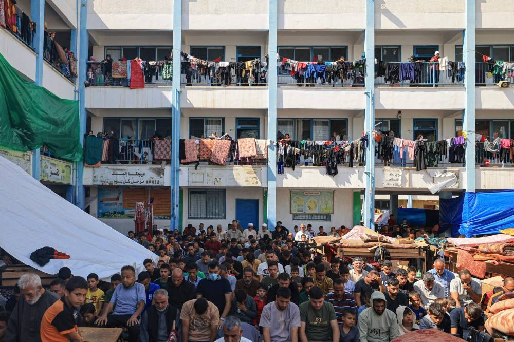 Displaced people gather for the Friday Noon prayers in  the yard of a United Nations Relief and Works Agency for Palestine Refugees (UNRWA) school in Khan Yunis, in the southern Gaza Strip on Friday. AFP