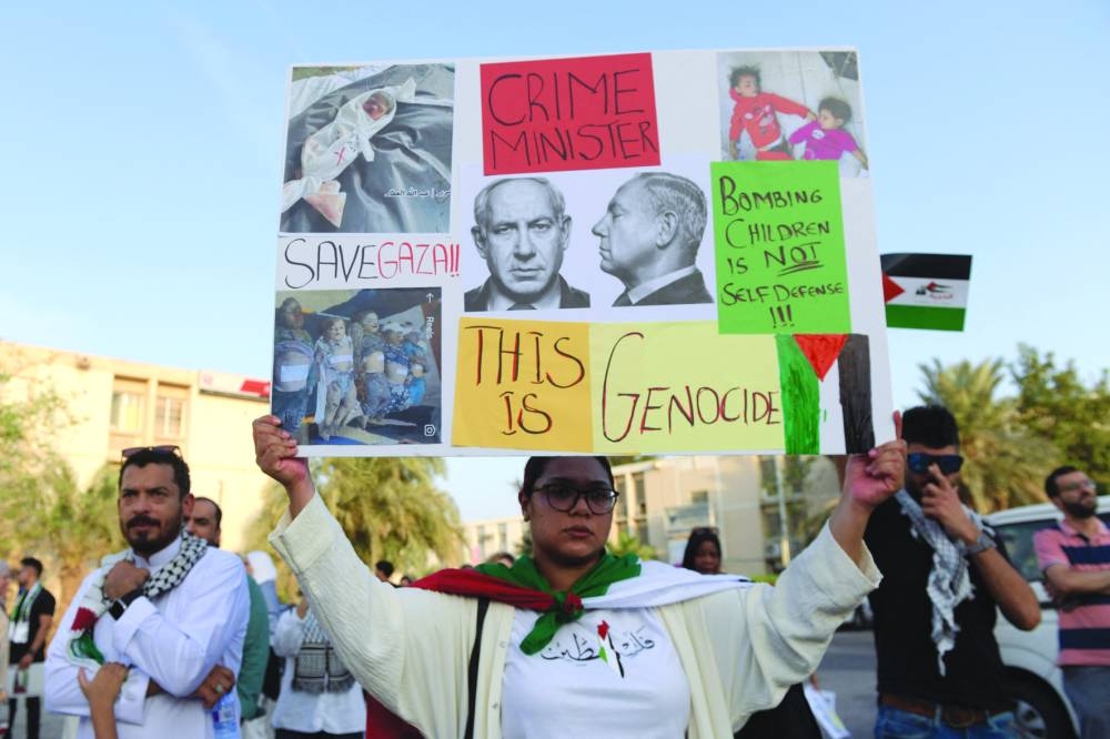 Bahrainis carry placards during a gathering in Manama on Friday, to express their solidarity with the Palestinian people.