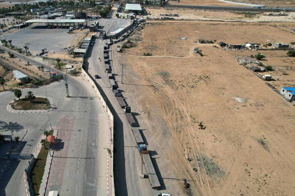 In this aerial view, a convoy of lorries carrying humanitarian aid enters the Gaza Strip from Egypt via the Rafah border crossing on on Saturday. AFP