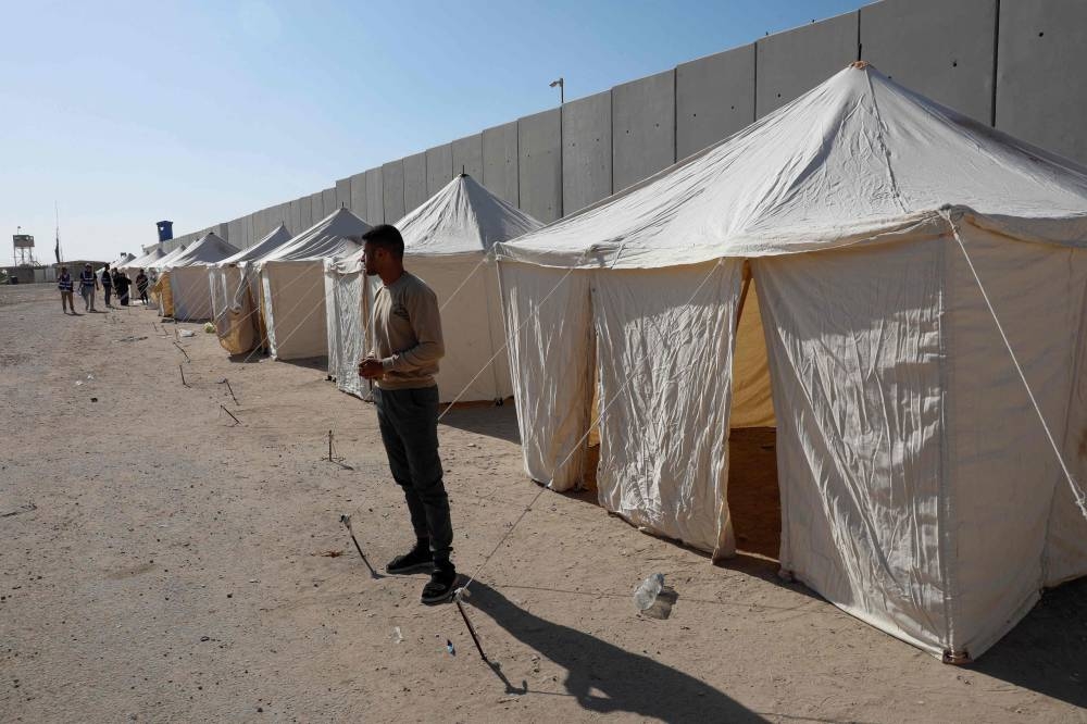 Volunteers and NGO workers stand near tents that they set up along the Egyptian side of the Rafah border crossing, demanding clearance for an aid convoy to enter the Gaza Strip, Thursday. AFP