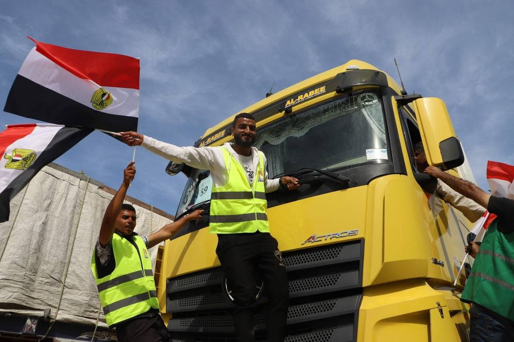 Egyptian aid workers celebrate as an aid truck crosses back into Egypt through the Rafah border crossing with the Gaza Strip on on Saturday. AFP